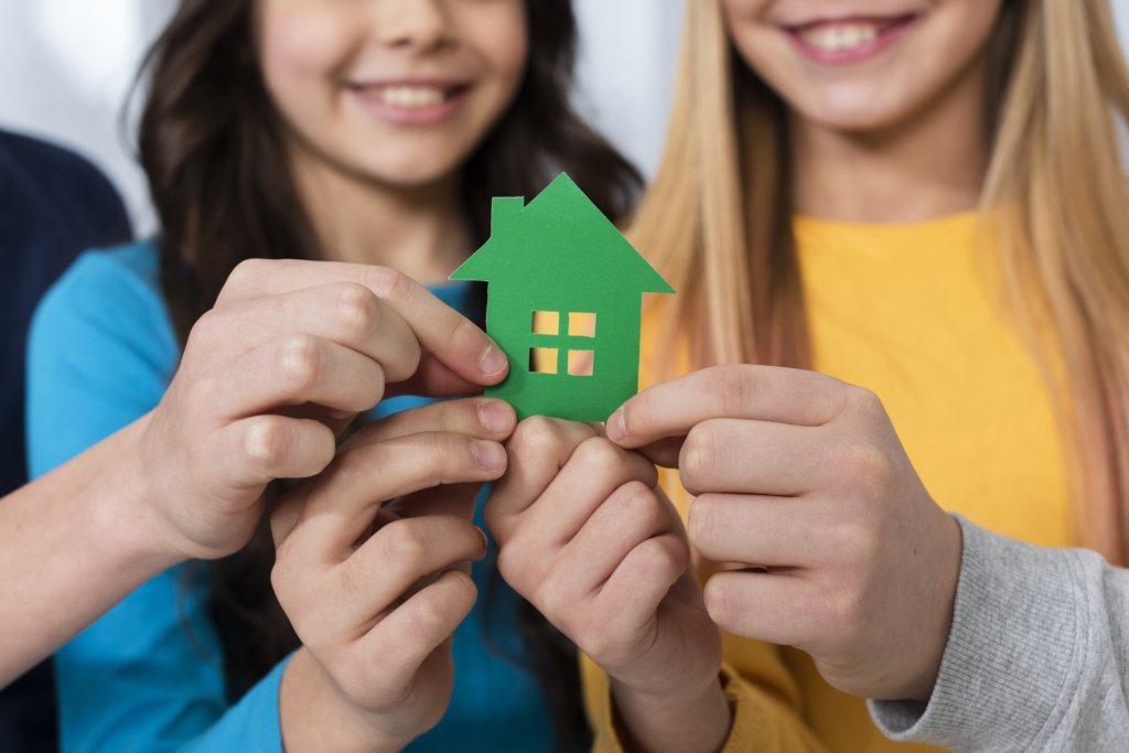 close up criancas segurando a casa de brinquedo